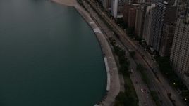4.8K aerial stock footage tilt from Lake Shore Drive, revealing Downtown Chicago buildings, on a cloudy day at sunset, Illinois Aerial Stock Footage | AX0003_074