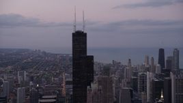4.8K aerial stock footage orbiting top of Willis Tower in Downtown Chicago, on a cloudy day at sunset, Illinois Aerial Stock Footage | AX0003_084