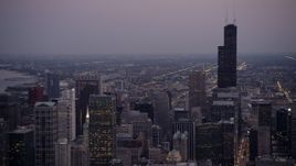 4.8K aerial stock footage of panning from Willis Tower across Downtown Chicago, on a hazy twilight, Illinois Aerial Stock Footage | AX0003_092