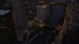 4.8K aerial stock footage of flying over a bridge spanning the Chicago River in downtown at twilight, Downtown Chicago, Illinois Aerial Stock Footage | AX0003_120