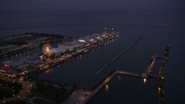 4.8K aerial stock footage of flying by a Ferris wheel and rides on Navy Pier at twilight, Chicago, Illinois Aerial Stock Footage | AX0003_122
