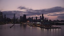 4.8K aerial stock footage orbit the end of Navy Pier at twilight, and reveal the skyline of Downtown Chicago, Illinois Aerial Stock Footage | AX0003_124