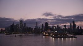 4.8K aerial stock footage of passing by the end of Navy Pier with a view of the Downtown Chicago skyline at twilight, Illinois Aerial Stock Footage | AX0003_125