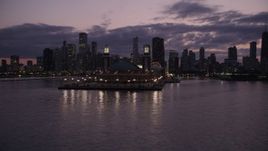 4.8K aerial stock footage orbit around the end of Navy Pier, revealing Downtown Chicago skyline at twilight, llinois Aerial Stock Footage | AX0003_127