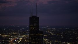 4.8K aerial stock footage of orbiting the top of the Willis Tower skyscraper at night with clouds, Downtown Chicago, Illinois Aerial Stock Footage | AX0003_150
