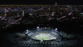 5K aerial stock footage orbit Dodger Stadium and tilt to reveal Downtown Los Angeles at night, California Aerial Stock Footage | AX0004_034