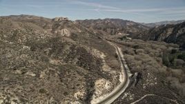 5K aerial stock footage follow train tracks toward rock formation in Santa Clarita, California Aerial Stock Footage | AX0005_021