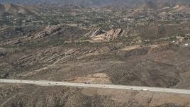 5K aerial stock footage approach Vasquez Rocks Park from the freeway in the Mojave Desert, California Aerial Stock Footage | AX0005_036