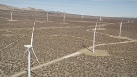 5K aerial stock footage fly over a row of windmills at a desert wind farm in California Aerial Stock Footage | AX0005_139