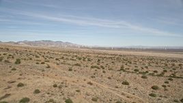 5K aerial stock footage fly over desert plants toward wind farm in Antelope Valley, California Aerial Stock Footage | AX0006_004E