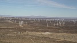 5K aerial stock footage pan across rows of windmills at desert wind farm in Antelope Valley, California Aerial Stock Footage | AX0006_006