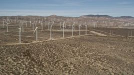 5K aerial stock footage approach a row of windmills at a wind farm in the Mojave Desert, California Aerial Stock Footage | AX0006_013
