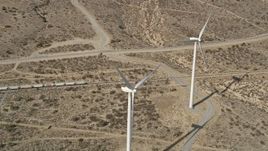 5K aerial stock footage of flyby a trio of windmills at a wind farm in the Mojave Desert, California Aerial Stock Footage | AX0006_016E