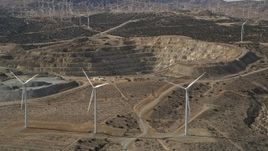 5K aerial stock footage pan across windmills near a quarry in the desert, Antelope Valley, California Aerial Stock Footage | AX0006_018