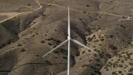 5K aerial stock footage tilt to a bird's eye view of a single windmill at a desert wind farm in Antelope Valley, California Aerial Stock Footage | AX0006_024