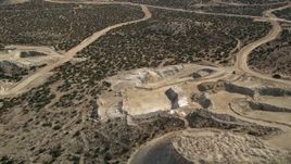 5K aerial stock footage fly over a small quarry at a wind farm in the Mojave Desert, California Aerial Stock Footage | AX0006_028