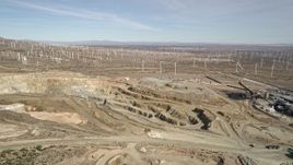 5K aerial stock footage orbit pit of desert quarry near windmills in Antelope Valley, California Aerial Stock Footage | AX0006_032E