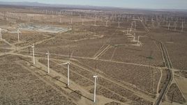 5K aerial stock footage tilt to bird's eye of a windmill in a desert wind farm in California Aerial Stock Footage | AX0006_041
