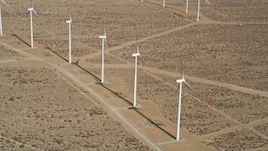 5K aerial stock footage fly over a row of windmills at a wind farm in the California desert Aerial Stock Footage | AX0006_050