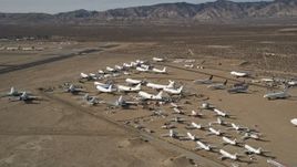 5K aerial stock footage orbit low around various jet airplanes at an aircraft boneyard in the desert, Mojave Air and Space Port, California Aerial Stock Footage | AX0006_058E