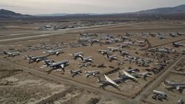 5K aerial stock footage orbiting an aircraft boneyard in the Mojave Desert, California Aerial Stock Footage | AX0006_061E
