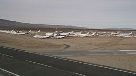 5K aerial stock footage of flyby jet airplanes in a desert field at a California boneyard, Mojave Air and Space Port Aerial Stock Footage | AX0006_071
