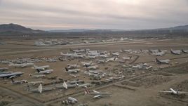 5K aerial stock footage circle over planes at an aircraft boneyard in the Mojave Desert, California Aerial Stock Footage | AX0006_082E