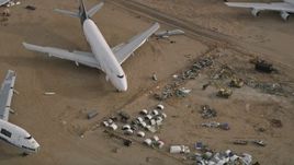 5K aerial stock footage tilt to bird's eye of jet airplane and components at a desert boneyard, Mojave Air and Space Port, California Aerial Stock Footage | AX0006_089