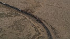 5K aerial stock footage of cargo train on a curved track in the Mojave Desert, California Aerial Stock Footage | AX0006_095E