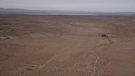 5K aerial stock footage pan across open desert to reveal a dry lake in Mojave Desert, California Aerial Stock Footage | AX0006_121