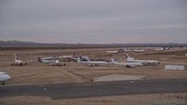 5K aerial stock footage of low altitude orbit around airliners at the Victorville Airport boneyard in California at Sunset Aerial Stock Footage | AX0007_003E