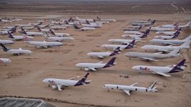 5K aerial stock footage orbit several rows of cargo planes in an aircraft boneyard at Sunset, Victorville Airport, California Aerial Stock Footage | AX0007_009