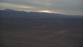 5K aerial stock footage pan across the Mojave Desert to distant mountains at Sunset, California Aerial Stock Footage | AX0007_019