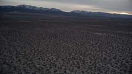 5K aerial stock footage tilt from desert to reveal mountains with light snow at twilight, Mojave Desert, California Aerial Stock Footage | AX0007_035