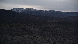 5K aerial stock footage fly over desert to approach mountains with light snow at twilight in Mojave Desert, California Aerial Stock Footage | AX0007_046