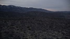 5K aerial stock footage fly over the Mojave Desert near distant mountains at twilight in California  Aerial Stock Footage | AX0007_047