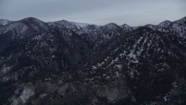 5K aerial  video orbiting snowy San Gabriel Mountains in wintertime at twilight, California Aerial Stock Footage | AX0008_007