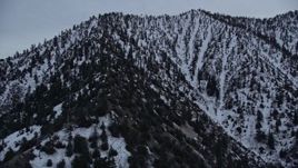 5K aerial stock footage orbit snowy mountain ridge and tilt to San Gabriel Mountains peak at twilight, California Aerial Stock Footage | AX0008_009
