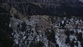 5K aerial stock footage of a mountain road with winter snow in the San Gabriel Mountains at twilight, California Aerial Stock Footage | AX0008_016