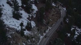 5K aerial stock footage of following road with winter snow through San Gabriel Mountains at twilight, California Aerial Stock Footage | AX0008_020E