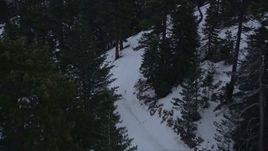 5K aerial stock footage follow slopes with winter snow to reveal a lift at Mount Baldy Ski Lifts at twilight, California Aerial Stock Footage | AX0008_024