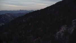 5K aerial stock footage of dense forest on snowy slopes in the San Gabriel Mountains at twilight, California Aerial Stock Footage | AX0008_033