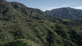 5K aerial stock footage fly over a dirt road in the San Gabriel Mountains and tilt to reveal tall peaks, California Aerial Stock Footage | AX0009_004E