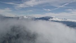 5K aerial stock footage fly over top of a cloud with a view of distant San Bernardino Mountains, California Aerial Stock Footage | AX0009_084E