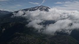 5K aerial stock footage of approaching clouds near a snowy peak in the San Bernardino Mountains, California Aerial Stock Footage | AX0009_086E