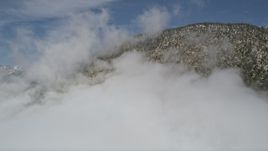5K aerial stock footage of San Bernardino Mountains with light winter snow and clouds, California Aerial Stock Footage | AX0009_114