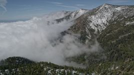 5K aerial stock footage of clouds blanketing snowy mountain slopes in the San Bernardino Mountains, California Aerial Stock Footage | AX0009_119