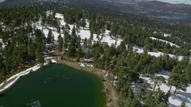 5K aerial stock footage orbit evergreens and ski runs on a snowy slope at Snow Summit in winter, California Aerial Stock Footage | AX0009_134E