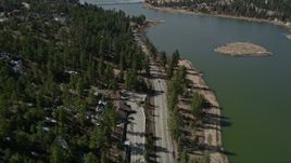 5K aerial stock footage tilt up to reveal Big Bear Lake near patches of light winter snow, California Aerial Stock Footage | AX0010_007