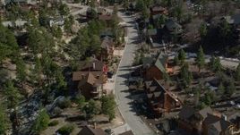 5K aerial stock footage orbit and fly over homes near Big Bear Lake with patches of winter snow, California Aerial Stock Footage | AX0010_010E